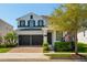 Charming two-story home with a brick driveway, two-car garage, and well-manicured landscaping under a clear blue sky at 8010 Soldierwood St, Winter Garden, FL 34787