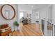 Bright hallway with wood floors, and desk area featuring decor and shelving, plus a decorative round mirror on the wall at 8010 Soldierwood St, Winter Garden, FL 34787