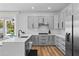 Charming kitchen with grey cabinets, stainless steel appliances, a black faucet, and wood-look flooring at 8010 Soldierwood St, Winter Garden, FL 34787