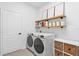 Modern laundry room with white appliances, shelving, and decor, providing a clean and functional space at 8010 Soldierwood St, Winter Garden, FL 34787