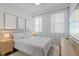 Inviting main bedroom featuring neutral tones, soft lighting, plush bedding, and bright, sheer curtains at 8010 Soldierwood St, Winter Garden, FL 34787