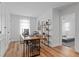 Bright office space with wood floors, a modern desk and chair, shelving, and a glimpse into an adjacent bedroom at 8010 Soldierwood St, Winter Garden, FL 34787