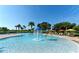 Resort-style community pool featuring splash fountain, lounge chairs, and beautiful landscaping on a sunny day at 8010 Soldierwood St, Winter Garden, FL 34787