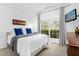 Bright bedroom featuring a large window and a comfortable bed with blue pillows at 8073 Santee Dr, Kissimmee, FL 34747