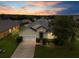 Inviting one-story home featuring a two-car garage, blue front door, and lush landscaping at 8073 Santee Dr, Kissimmee, FL 34747