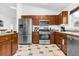 Modern kitchen with stainless steel appliances, wood cabinets, and neutral tile flooring at 8073 Santee Dr, Kissimmee, FL 34747