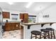 Open kitchen with wood cabinets, a bar, and modern appliances at 8073 Santee Dr, Kissimmee, FL 34747