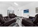 Bright living room with dark leather furniture, a vaulted ceiling, and a view of the pool at 8073 Santee Dr, Kissimmee, FL 34747