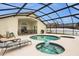 Screened-in pool and hot tub area with outdoor furniture and a dining table at 8073 Santee Dr, Kissimmee, FL 34747