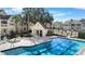 Beautiful community pool area featuring a pool house, lounge chairs, and well-manicured landscaping at 1033 S Hiawassee Rd # 2628, Orlando, FL 32835