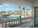 A screened-in view of the pool, palm trees, and multiple apartment buildings at 1033 S Hiawassee Rd # 2628, Orlando, FL 32835