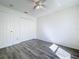 Bedroom featuring neutral walls, laminate flooring, a ceiling fan and double door closet at 1049 Winding Water Way, Clermont, FL 34714