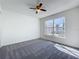 Bright bedroom with neutral walls, carpet, ceiling fan and large window, creating a calm and inviting atmosphere at 1049 Winding Water Way, Clermont, FL 34714