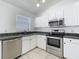 Well-lit kitchen with modern stainless steel appliances and bright white cabinetry at 1049 Winding Water Way, Clermont, FL 34714