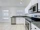 Modern kitchen featuring stainless steel appliances and bright white cabinets at 1049 Winding Water Way, Clermont, FL 34714