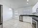 Open kitchen area with stainless steel appliances and bright white cabinetry at 1049 Winding Water Way, Clermont, FL 34714