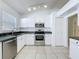 Bright kitchen featuring stainless steel appliances, white cabinets, and tiled floors at 1049 Winding Water Way, Clermont, FL 34714