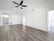 A bright living room showcasing hard surface flooring, ceiling fan, and an open doorway at 1049 Winding Water Way, Clermont, FL 34714