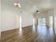 A living room featuring wood-look flooring, high ceilings, and a sliding door leading to the pool area at 1049 Winding Water Way, Clermont, FL 34714