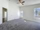 A main bedroom featuring carpeted floors, a ceiling fan, and windows offering natural light at 1049 Winding Water Way, Clermont, FL 34714