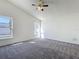 A main bedroom featuring carpeted floors, a ceiling fan, and windows allowing natural light at 1049 Winding Water Way, Clermont, FL 34714