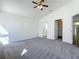 A main bedroom featuring carpeted floors, ceiling fan, and access to the primary bathroom at 1049 Winding Water Way, Clermont, FL 34714