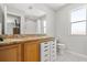 Bright bathroom featuring a granite countertop vanity, white cabinets, and a window for natural light at 122 Capri Dr, Davenport, FL 33897