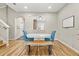 Dining room featuring blue chairs, white table, bench seating, hardwood flooring, and view to kitchen at 122 Capri Dr, Davenport, FL 33897