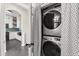 Convenient laundry area with a stacked washer and dryer, complemented by a view into the kitchen at 122 Capri Dr, Davenport, FL 33897