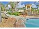 Inviting pool featuring a water slide, tropical landscaping, and a cabana for a resort-like experience at 122 Capri Dr, Davenport, FL 33897