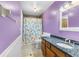 Colorful bathroom with a mermaid-themed shower curtain, a dark granite countertop, and a neutral tiled floor at 12235 Warren Rd, Clermont, FL 34711