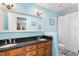 Bright bathroom features a double vanity with black granite and a shower-tub with a white curtain at 12235 Warren Rd, Clermont, FL 34711