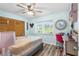 A cozy bedroom with wood-look flooring has a pink desk and a window view of the outdoors at 12235 Warren Rd, Clermont, FL 34711