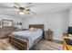 This bedroom features wood-look flooring, a ceiling fan, a wooden bedroom set, and neutral walls at 12235 Warren Rd, Clermont, FL 34711