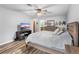 A well-lit bedroom boasts wood-look floors, a ceiling fan, and a television for entertainment at 12235 Warren Rd, Clermont, FL 34711