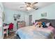 Bright bedroom featuring wood-look floors, a ceiling fan, and a cozy, comfortable bed at 12235 Warren Rd, Clermont, FL 34711