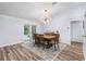 Dining room with a stylish light fixture, wood table, and access to the outdoor patio at 12235 Warren Rd, Clermont, FL 34711