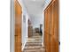 Hallway view with wood look flooring, leading to bedrooms and featuring closet and dresser storage at 12235 Warren Rd, Clermont, FL 34711