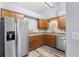 Well-lit kitchen with stainless steel appliances, wood cabinets, granite countertops and tile backsplash at 12235 Warren Rd, Clermont, FL 34711