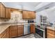 Kitchen with stainless steel appliances, light granite countertops, wood cabinets and hardwood flooring at 12235 Warren Rd, Clermont, FL 34711