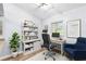 Home office featuring built-in shelving, a work desk, a cozy chair and a large window with natural light at 12235 Warren Rd, Clermont, FL 34711