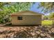 View of the back exterior with trees and a small window on the stucco wall at 1306 Shepherd Ave, Sanford, FL 32771