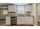 Modern kitchen featuring stainless steel dishwasher, granite countertops, and white cabinetry at 1306 Shepherd Ave, Sanford, FL 32771