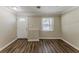 Cozy living room featuring luxury vinyl plank flooring, a window, and a white front door at 1306 Shepherd Ave, Sanford, FL 32771