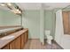 Well-lit bathroom featuring a double vanity, toilet, and shower tub at 13427 Blue Heron Beach Dr # 103, Orlando, FL 32821