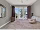 Cozy bedroom with plush bed, sliding glass door to balcony with lake views at 13427 Blue Heron Beach Dr # 103, Orlando, FL 32821