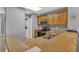 Kitchen featuring wood cabinets, granite countertops, stainless steel appliances, and tile floor at 13427 Blue Heron Beach Dr # 103, Orlando, FL 32821