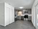 Well-lit kitchen features stainless steel appliances, gray cabinetry, and durable gray tile flooring at 145 W Fern Dr, Orange City, FL 32763