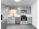 Modern kitchen with stainless steel appliances, gray cabinets, and subway tile backsplash, perfect for cooking at 145 W Fern Dr, Orange City, FL 32763