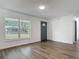 Bright living room featuring hardwood floors, fresh paint, and a large window for ample natural light at 145 W Fern Dr, Orange City, FL 32763